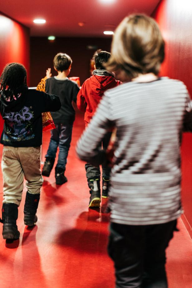 Eine Kindergruppe in einem roten Kinokorridor