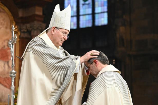 Kardinal Christoph Schönborn legt Josef Grünwidl im Stephansdom die Hand auf den Kopf und weiht ihn feierlich zum neuen Erzbischof von Wien.