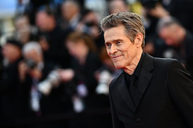 Der Schauspieler Willem Dafoe bei einem Festivalauftritt vor größerer Menschenmenge 