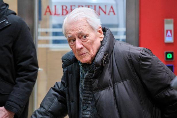 Alexander Kluge in einem Raum, an einer Tür die Aufschrift "Albertina"