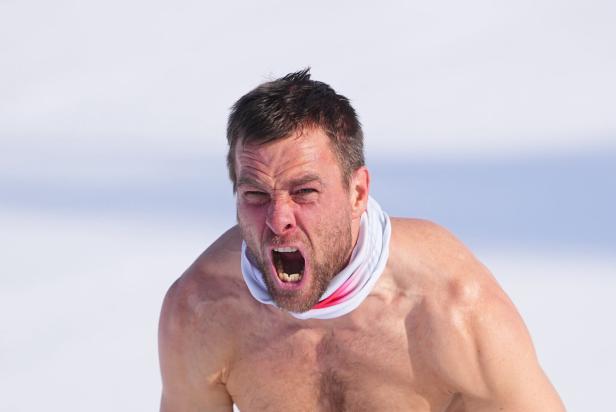 Benjamin Karl, Snowboard Olympiasieger, brüllt mit nacktem Oberkörper nach seinem Sieglauf