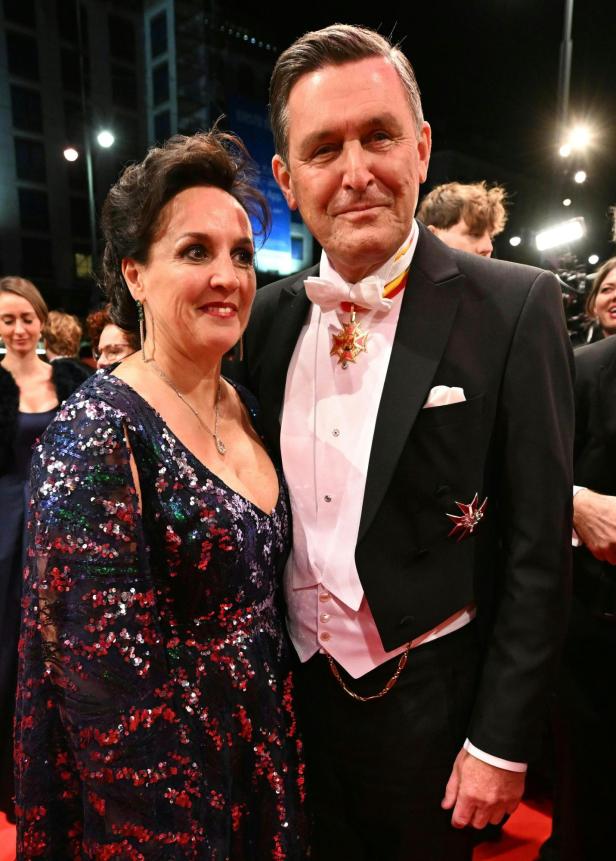 Ein elegant gekleidetes Paar, SPÖ-Minister Hanke mit Gattin, posiert auf dem roten Teppich beim Opernball.