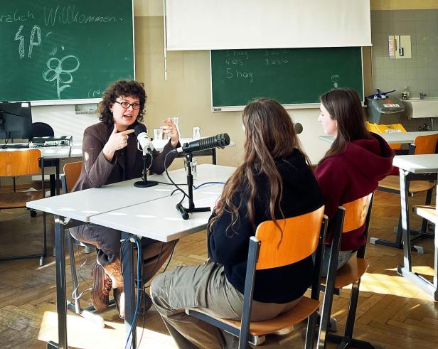 Alexandra Stanić im Gespräch mit zwei Schülerinnen bei einer Podcastaufnahme.