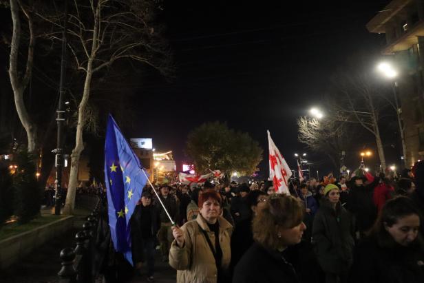Menschenmenge, man sieht eine EU- und eine georgische Flagge.