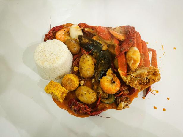 Da Bild zeigt die ausgeschüttete Seafood Boil mit Reis und Königskrabbe