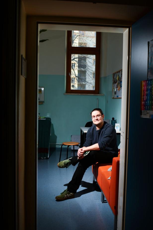 Ein junger Sozialarbeiter sitzt in seinem Arbeitszimmer