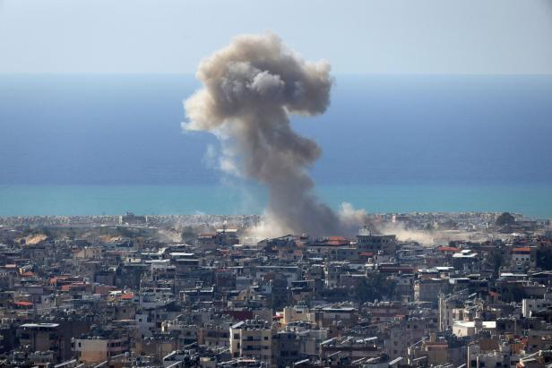 Eine Stadt am Meer, mitten drin Rauch von einem Rakteneinschlag