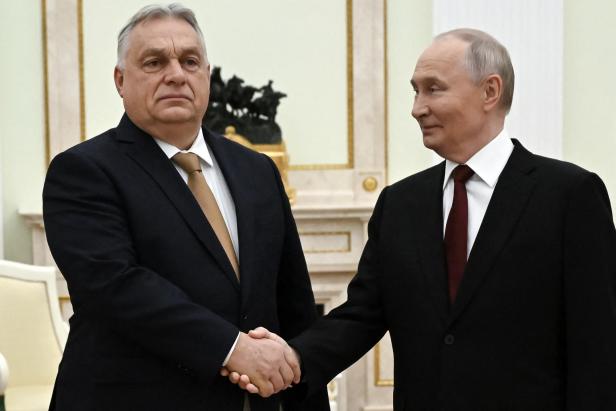 Orban schüttelt die Hand von Wladimir Putin.