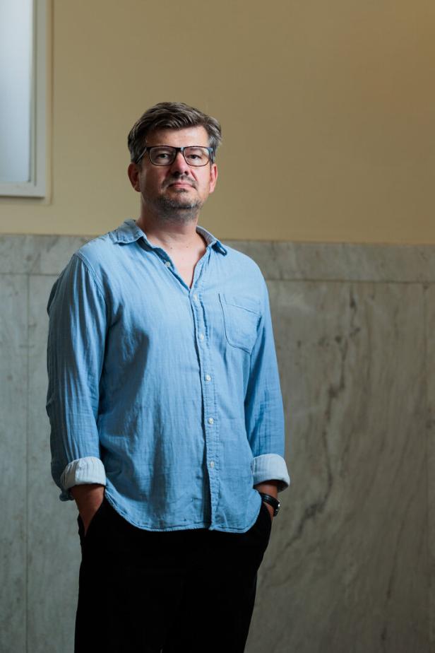 Regisseur Pavel Cuzuioc posiert in blauem Hemd für ein Foto