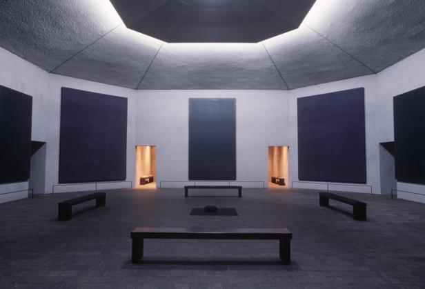 Innenansicht eines achteckigen Ausstellungsraums mit dunklen monochromen Gemälden an der Wand: Die Rothko Chapel in Houston, Texas