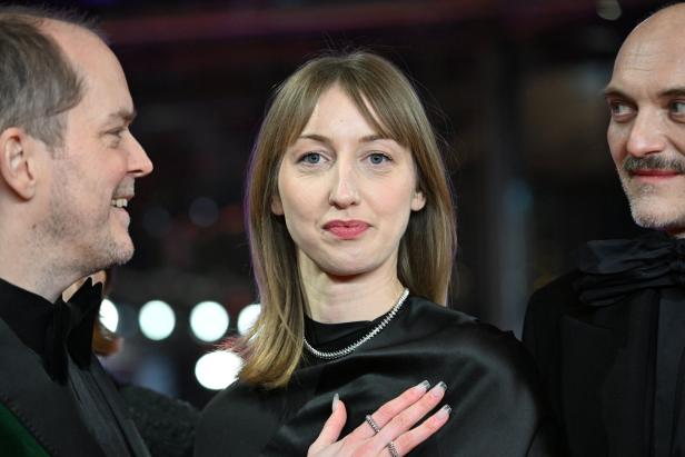 Die Schauspielerin Caro Braun, 26, vor dunklem Hintergrund, flankiert von ihrem Kollegen Godehard Giese und Regisseur Schleinzer 
