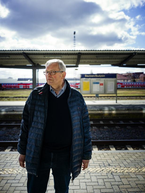 Ein Mann in Anorak steht auf einem Bahnsteig in Bautzen, Deutschland