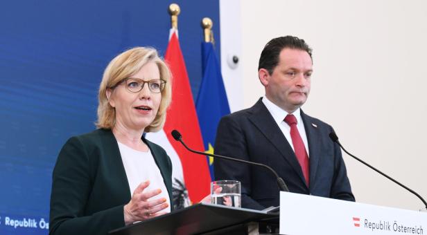 Zwei Personen - die Politiker Gewessler und Totschnig - sprechen bei einer Pressekonferenz vor österreichischer und EU-Flagge.