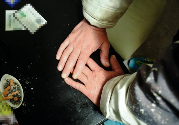 Zu sehen sind zwei Arme in Bauarbeiterkluft