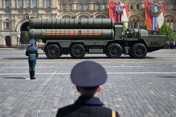 Ein Wagen mit Raketen fährt an einem Soldaten vorbei.