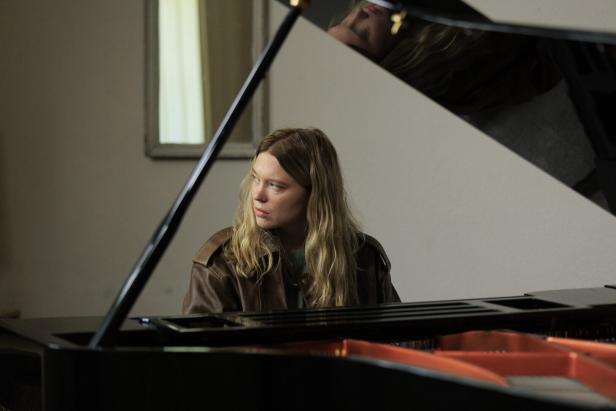 Die französische Schauspielerin Léa Seydoux sitzt mit versunkenem Blick in einem Innenraum an einem Konzertflügel