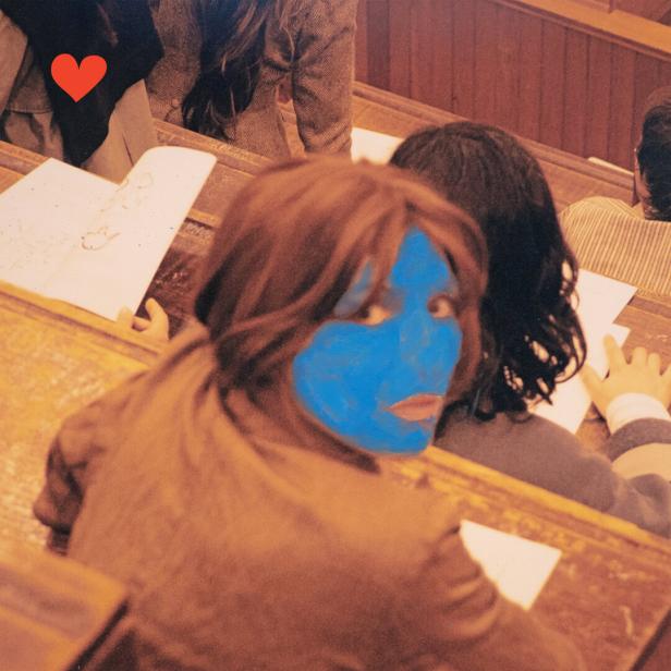Plattencover der Sängerin Aldous Harding, die da in einem Hörsaal sitzt und mit digital blau gefärbtem Gesicht sich zur Kamera hin umdreht