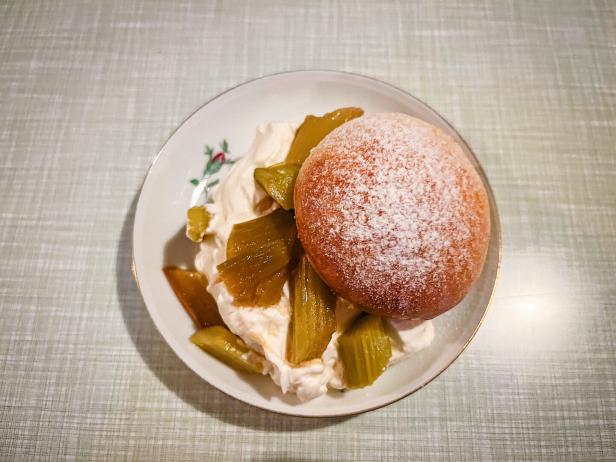 Das Bild zeigt einen Brioche-Krapfen mit Rhabarberkompott und Schlag