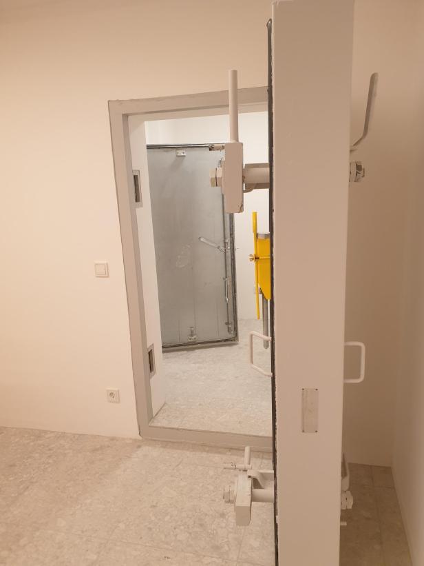 Eine geöffnete Schutzraumtür. Sie ist rund 30 cm dick.