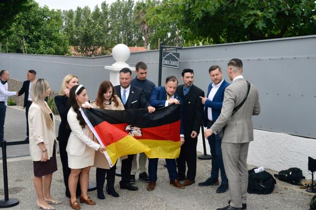 Die Abordnung des "Deutschland-Kurier" stellt sich mit Deutschland-Flagge zum Erinnerungsfoto auf.