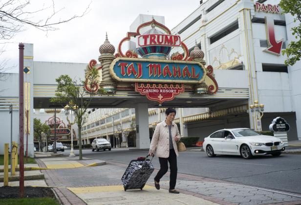 Eine Frau geht an einem Gebäude mit der Aufschrift „Trump Taj Mahal“ vorbei.