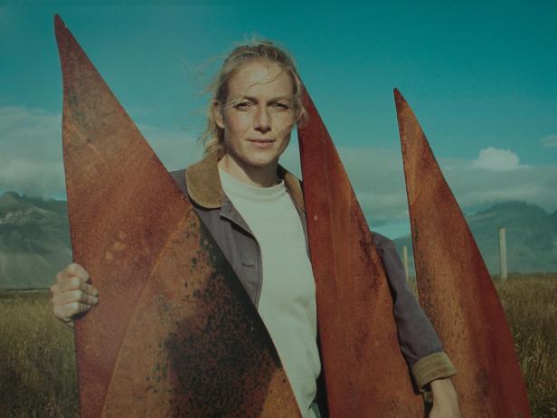 Die Schauspielerin Saga Garðarsdóttir posiert mit rostigen Metallstücken in freier Natur