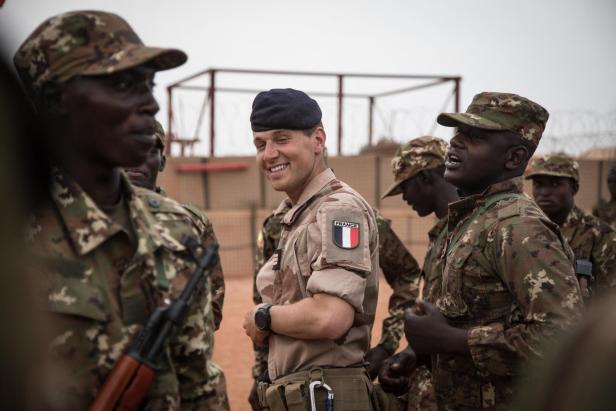 Ein französischer Soldat und malische Soldaten tanzen gemeinsam.