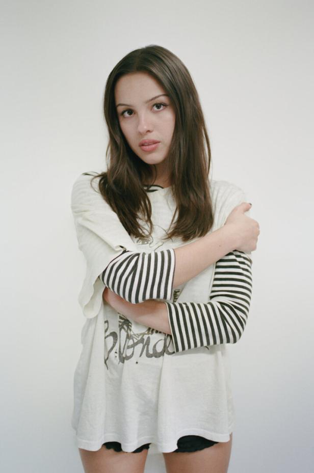 Die Musikerin Olivia Rodrigo in einem weißen T-Shirt blickt ernst in die Kamera.