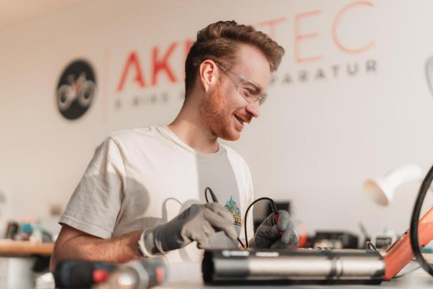 Mann repariert Fahrrad-Akku
