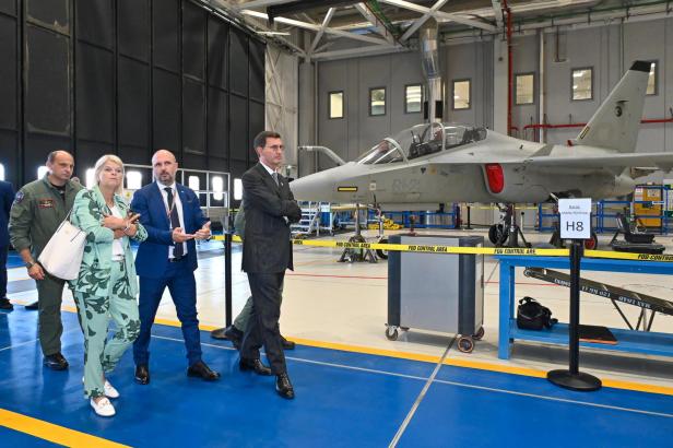 Verteidigungsministerin Tanner wird durch einen Flugzeughangar geführt.