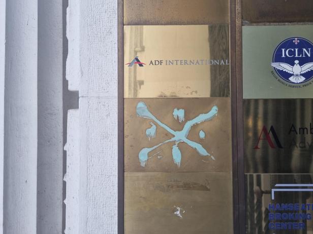 Goldene Firmenschilder, auf einem steht "ADF International" mitsamt Logo.