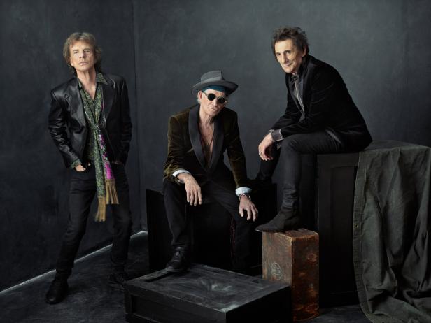 Das britische Trio The Rolling Stones posiert in einem dunklen Raum 