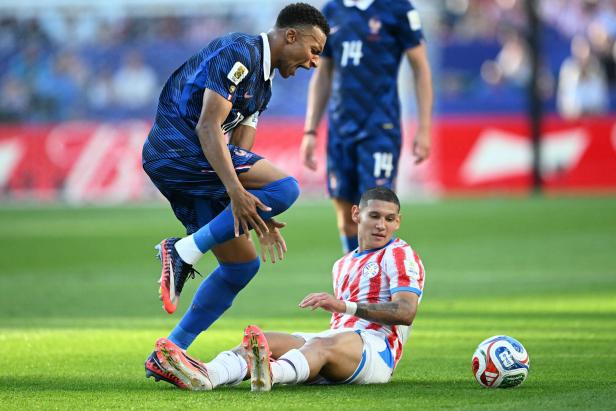  Kylian Mbappe wird von Paraguays Juan Jose Caceres am Fuß getroffen 
