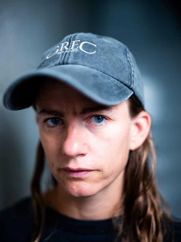 Porträt der Künstlerin Florentina Holzinger, die mit ernstem Gesicht und Baseball-Kappe auf dem Kopf in die Kamera schaut