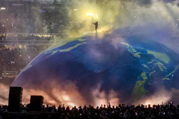 Anstatt auf einer klassischen Bühne tritt Kanye West auf einem Globus, dem Dome, auf. 