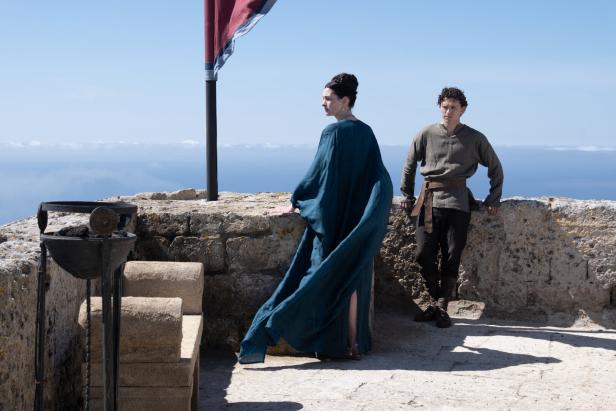 Anne Hathaway und Tom Holland stehen in historischen Kostümen auf einer Burgterrasse, über ihnen blauer Himmel