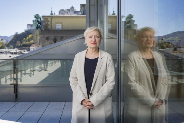 Festspiele-Intendantin Karin Bergmann auf einer Salzburger Terrasse, neben verglaster Tür