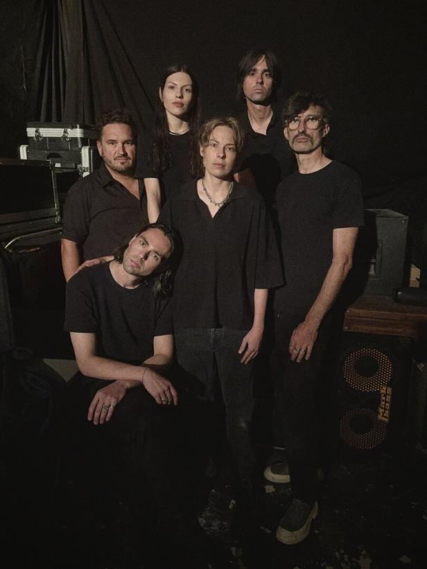 Die sechsköpfige Band Exit Void, schwarz gekleidet, vor schwarzem Hintergrund
