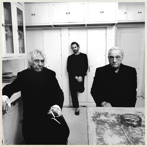Schwarzweißes Foto dreier älterer, ernst in die Kamera blickender Herren: John Cale und Martin Scorsese sitzen im Vordergrund, Marc Jacobs lehnt an der Rückwand.