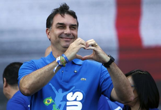 Flávio Bolsonaro macht mit seinen Händen ein Herz.
