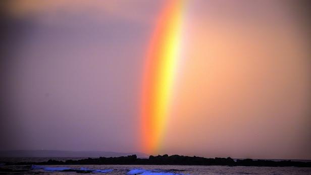 Ein Regenbogen, der bei Sonnenuntergang am Narrawallee Beach in Mollymook, etwa 224 Kilometer südlich von Sydney, hinter einem Surfer erscheint. Ein Regenbogen, der bei Sonnenuntergang am Narrawallee Beach in Mollymook, etwa 224 Kilometer südlich von Sydney, hinter einem Surfer erscheint.