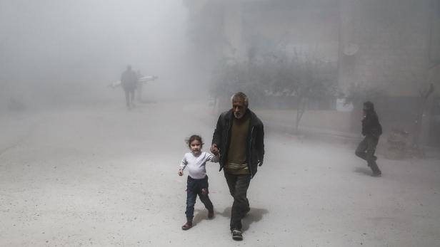 Flucht nach einem Luftwaffenangriff in der von Rebellen gehaltenen syrischen Stadt Hamouria.