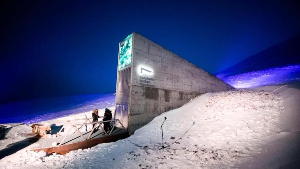 Menschen vor dem Eingang zur internationalen Genbank Svalbard Global Seed Vault (SGSV) außerhalb von Longyearbyen auf Spitzbergen, Norwegen. Das arktische "Weltuntergangsgewölbe" soll 60.000 Proben von Saatgut aus der ganzen Welt als größte globale Erntev Menschen vor dem Eingang zur internationalen Genbank Svalbard Global Seed Vault (SGSV) außerhalb von Longyearbyen auf Spitzbergen, Norwegen. Das arktische "Weltuntergangsgewölbe" soll 60.000 Proben von Saatgut aus der ganzen Welt als größte globale Erntev
