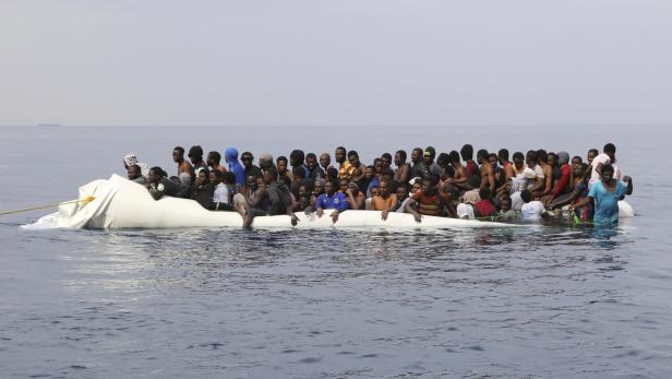 Migranten auf einem sinkenden Boot vor der libyschen Küste. Migranten auf einem sinkenden Boot vor der libyschen Küste.