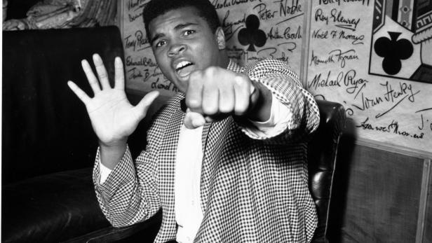 Mai 1963: Der Boxer Cassius Clay, bekannt als Muhammad Ali, zeigt sich vor seinem Kampf gegen Henry Cooper sehr selbstbewusst. In nur fünf Runden will er seinen Gegner ausknocken. Mai 1963: Der Boxer Cassius Clay, bekannt als Muhammad Ali, zeigt sich vor seinem Kampf gegen Henry Cooper sehr selbstbewusst. In nur fünf Runden will er seinen Gegner ausknocken.