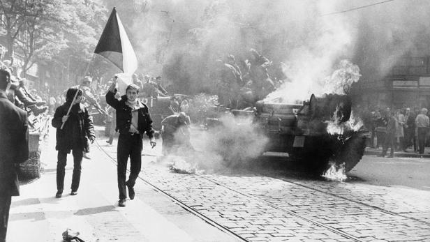 Einwohner von Prag mit tschechoslowakischer Flagge vor einem sowjetischen Panzer