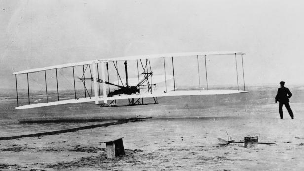 Die Gebrüder Wright bei ihrem ersten Flug mit ihrer "Kitty Hawk".