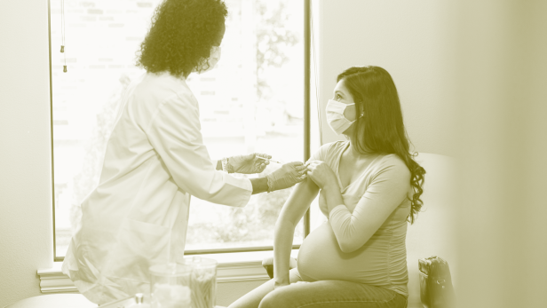 Eine schwangere Frau wird geimpft