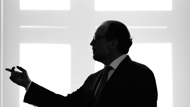 Die Silhouette eines Mannes im Anzug, der gestikuliert.