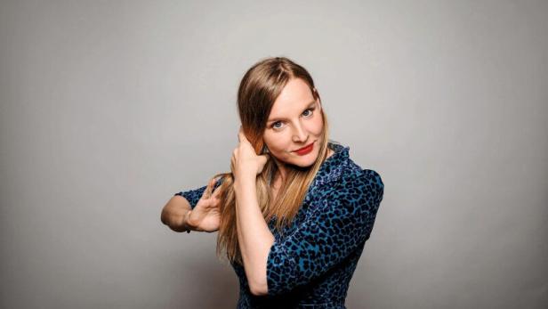 Judith Holofernes posiert vor einem grauen Hintergrund.
